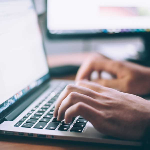 Image of person typing on a laptop